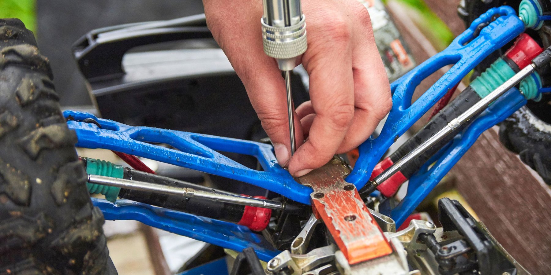 Hands working on RC car suspension