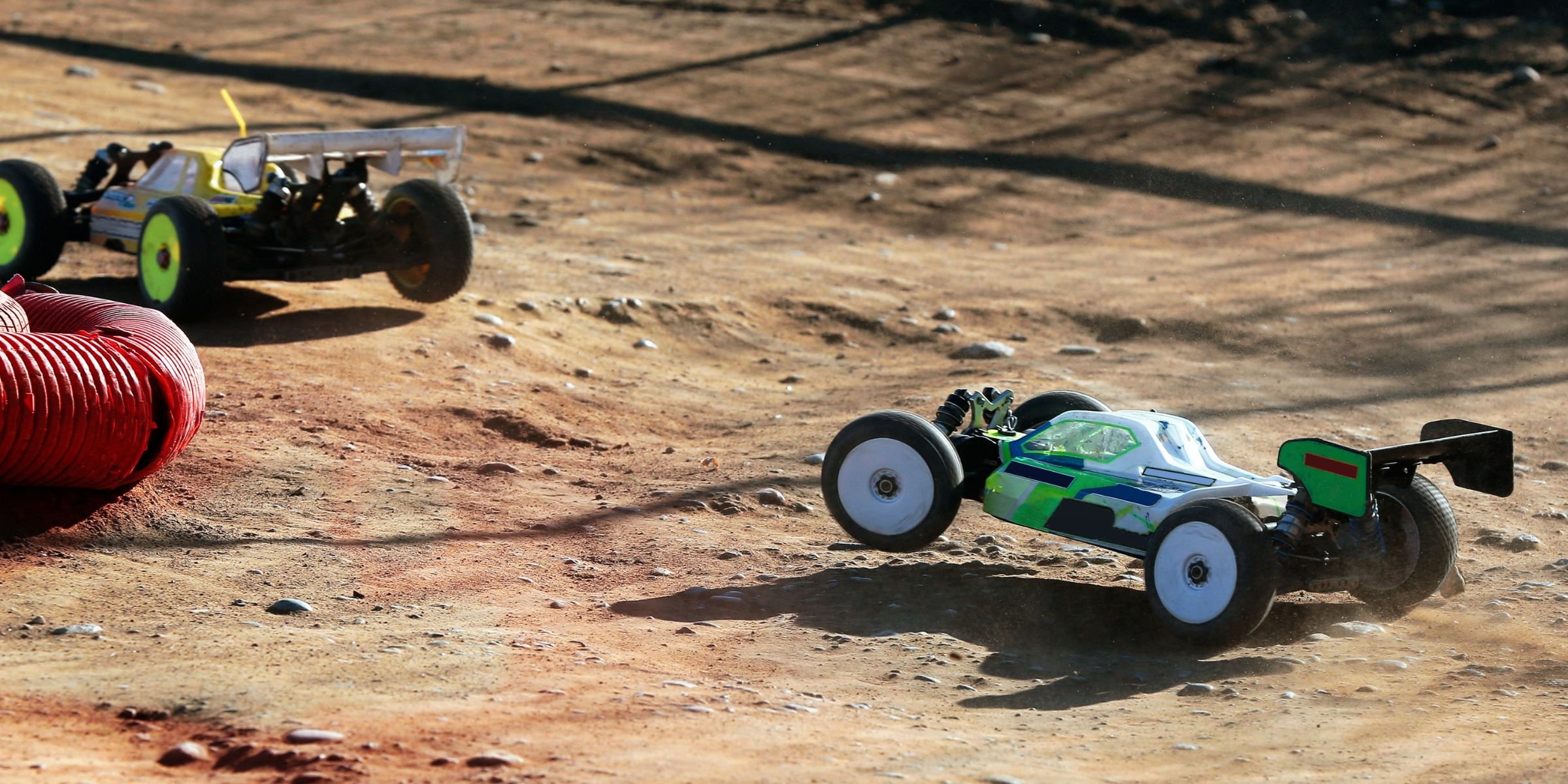RC buggies cornering on dirt track